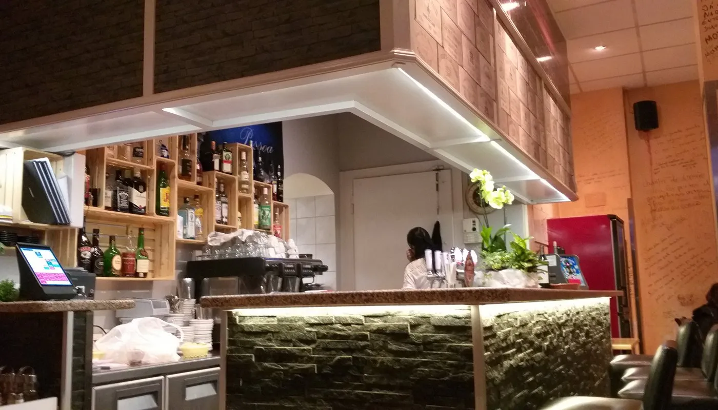 Le comptoir du restaurant Pessoa à Genève, ses bières et vins portugais et l'affiche de Lisbonne en arrière-plan.